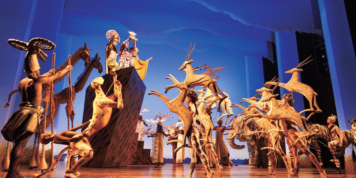 A vibrant illustration from Disney's The Lion King featuring various animals in a lush, colourful landscape.