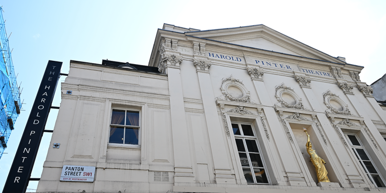 The Harold Pinter Theatre features a red brick exterior with large glass doors and a vibrant marquee.