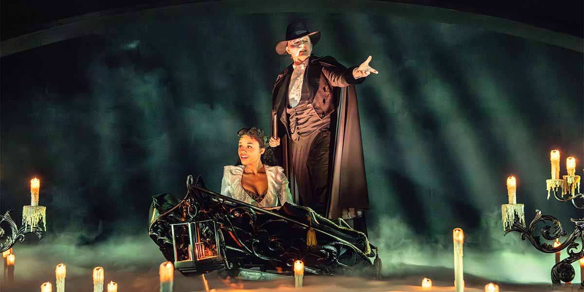 Beatrice Penny-Touré as Christine Daaé sits in a boat, while Dean Chisnall as The Phantom gestures dramatically.