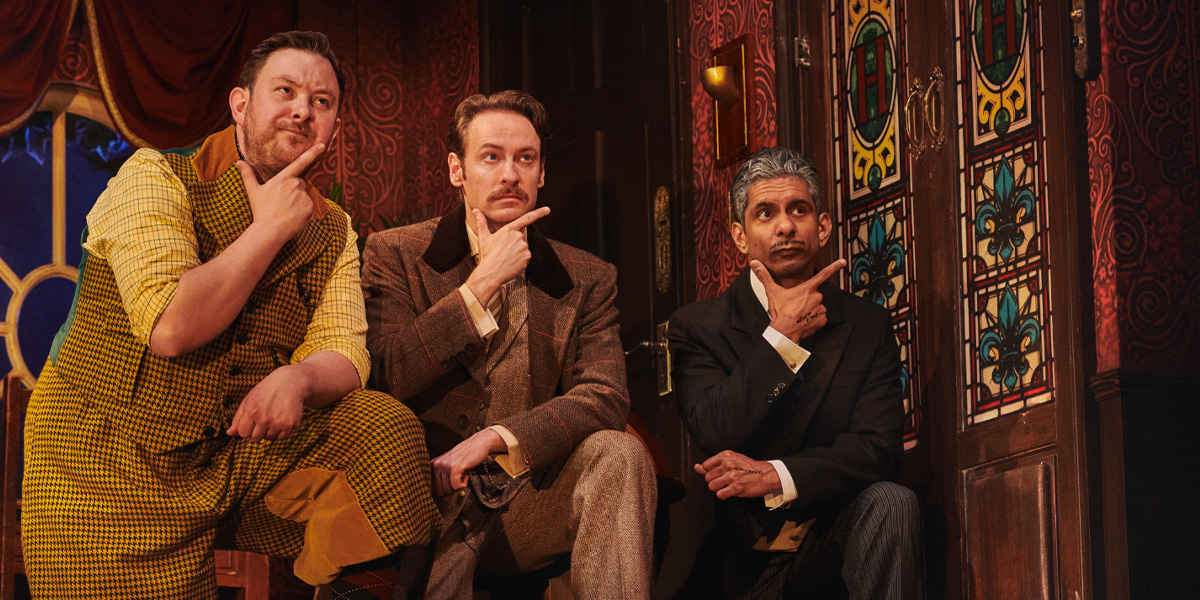 A chaotic scene from "The Play That Goes Wrong," featuring actors in disarray amidst a set collapse.