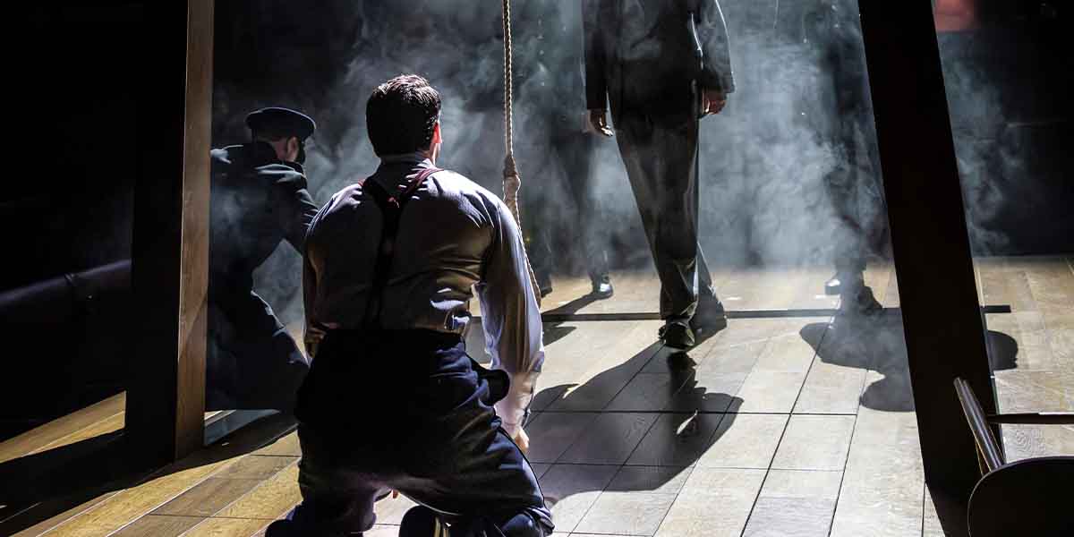 A dramatic scene from "Witness For The Prosecution," featuring actors in fog, with a noose visible.