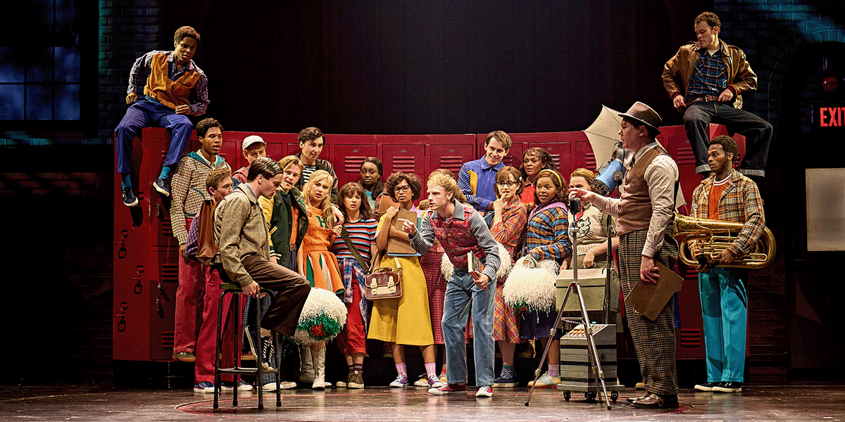A group of four characters in 1980s attire stands in a dimly lit, atmospheric setting, engaged in conversation.