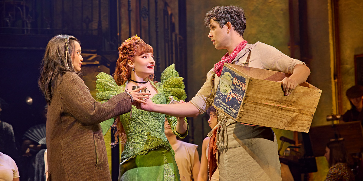 Desmonda and Cathabel, dressed in flowing costumes, perform on stage with dramatic lighting and expressive poses.