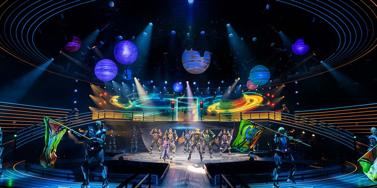 A vibrant scene from Starlight Express featuring colourful costumes and dynamic poses of performers on stage.