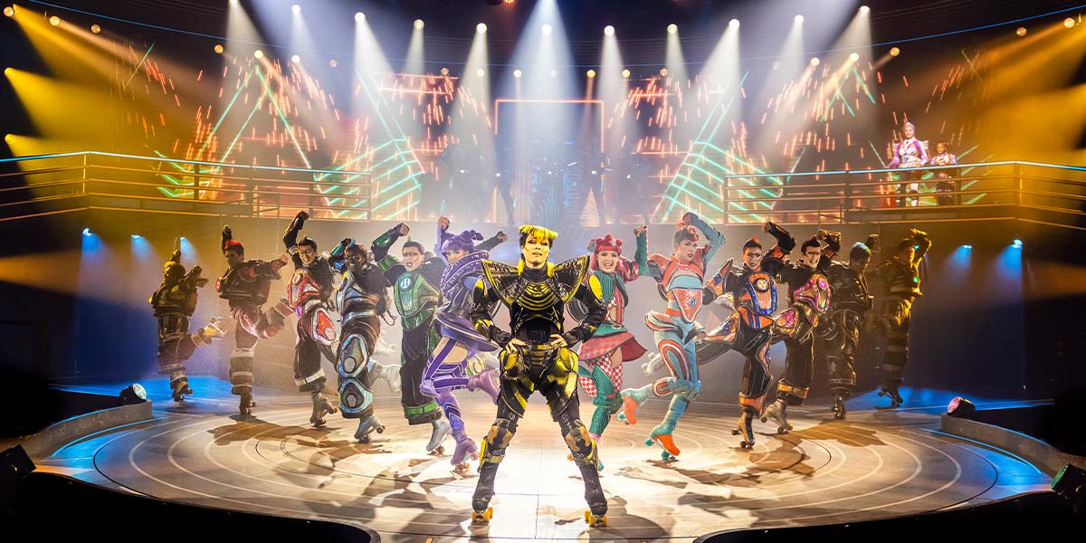A vibrant scene from Starlight Express featuring performers in colourful costumes, showcasing dynamic poses on stage.
