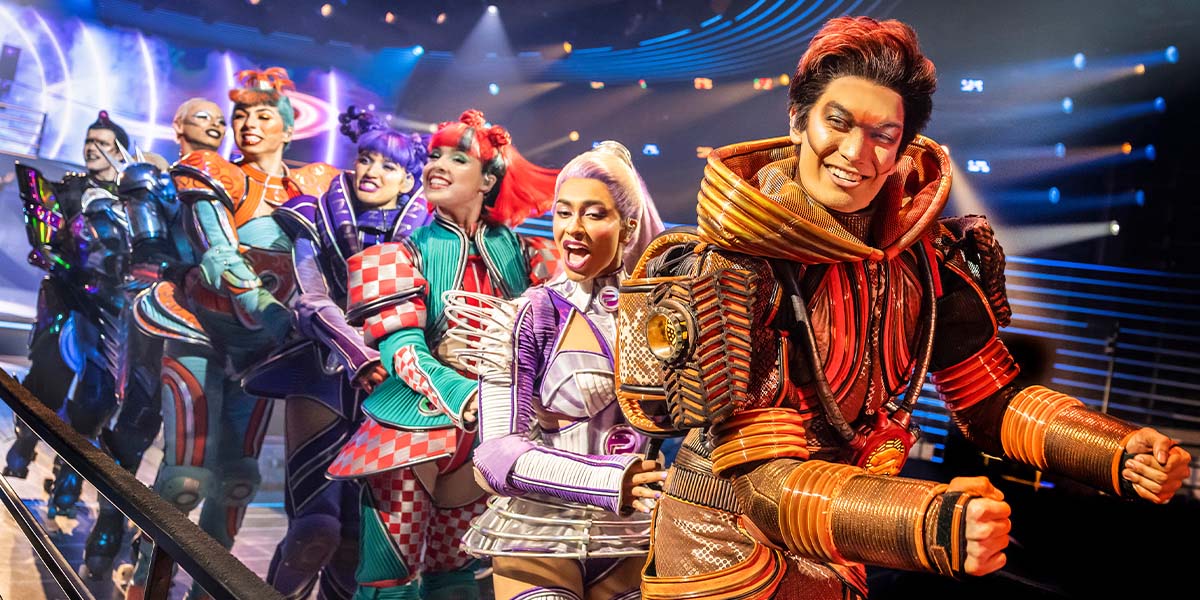 A vibrant scene from Starlight Express featuring performers in colourful costumes, showcasing dynamic poses on roller skates.