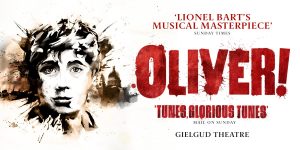 A performer in a vibrant costume strikes a dramatic pose on stage, with colourful lights illuminating the background.