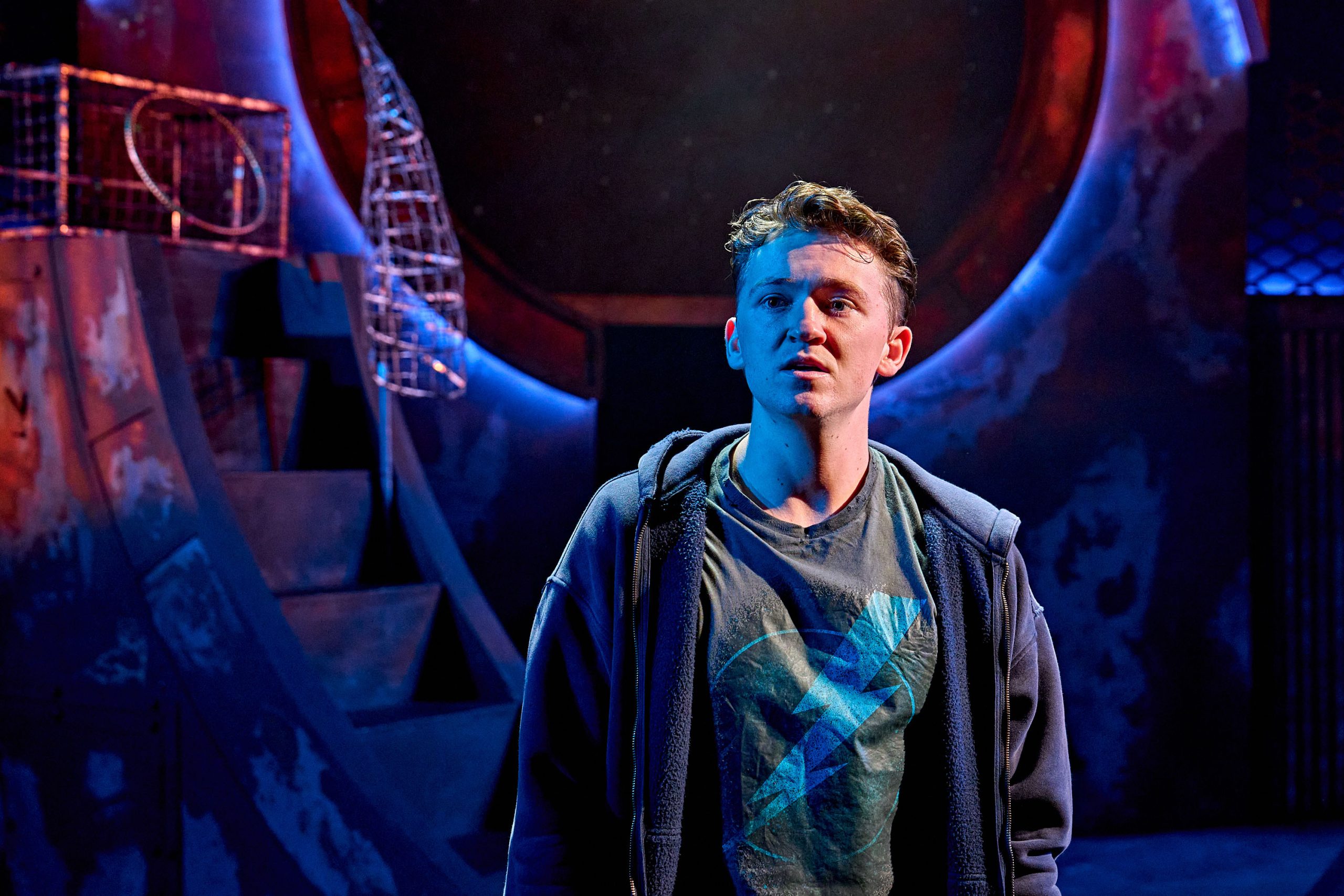 Percy Jackson is standing, facing the camera. They are staring off into the distance.