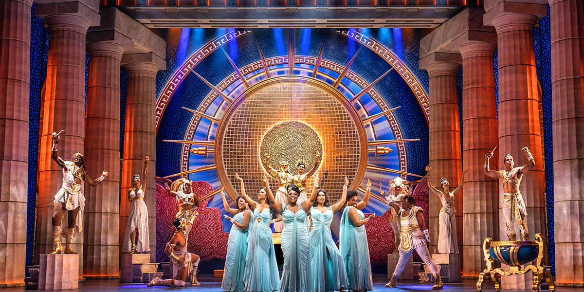 Five Muses in flowing dresses, singing and dancing on Mount Olympus, surrounded by clouds and vibrant colours.