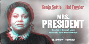 Mrs President stands confidently, wearing a tailored suit, against a neutral background, smiling warmly at the camera.