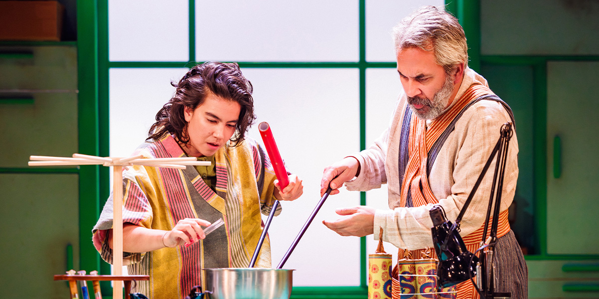 Two people in a vibrant costume make fireworks.