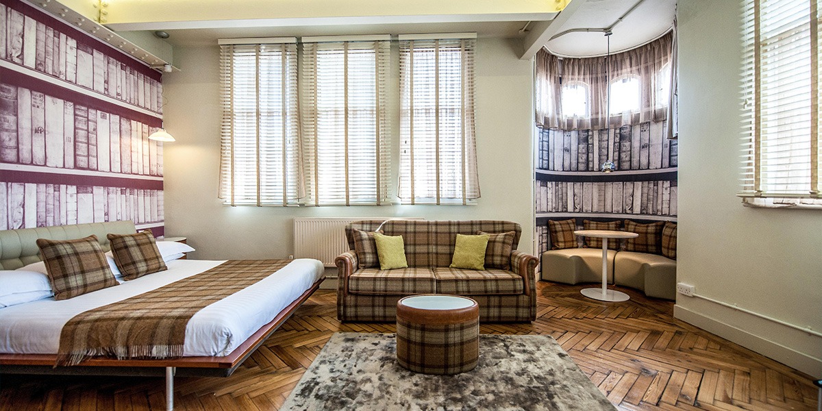 A hotel room with a bed and sofa