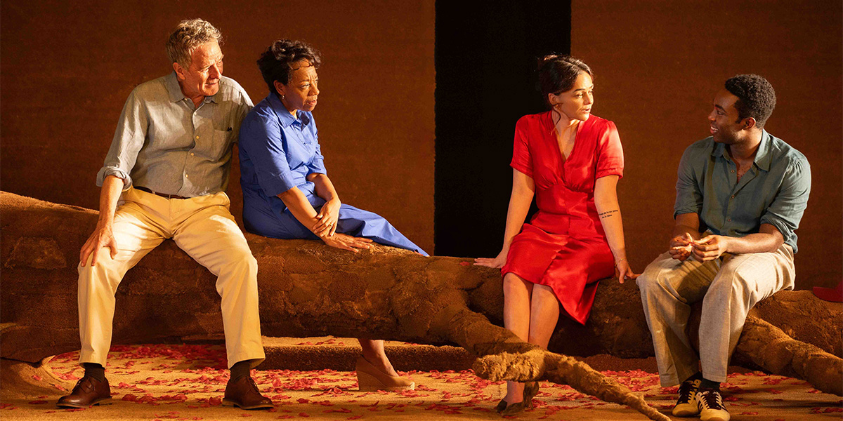 Bryan Cranston, Marianne Jean-Baptiste, Hayley Squires, and Paapa Essiedu pose together in a dramatic scene sitting on a brown sofa.