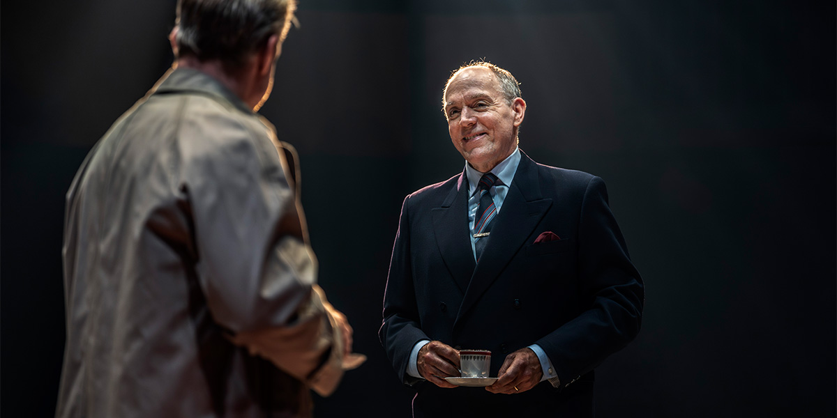 Ian Drysdale and Rory Keenan interact on stage, with Drysdale smiling and holding a glass.