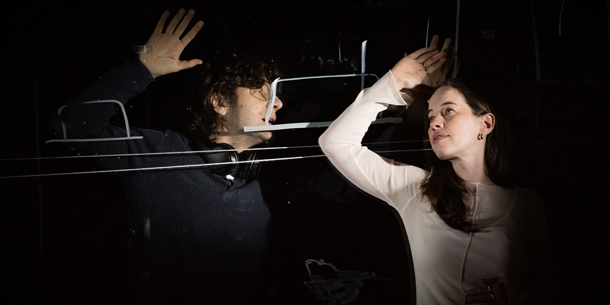Alexander Forsyth as Abe and Anna Popplewell as Julia, both in period costumes, are engaged in conversation.