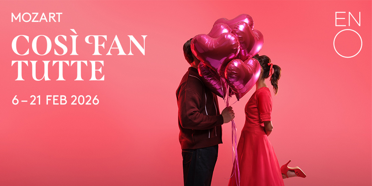 Two elegantly dressed women in 18th-century attire interact on a stage, with ornate curtains in the background.