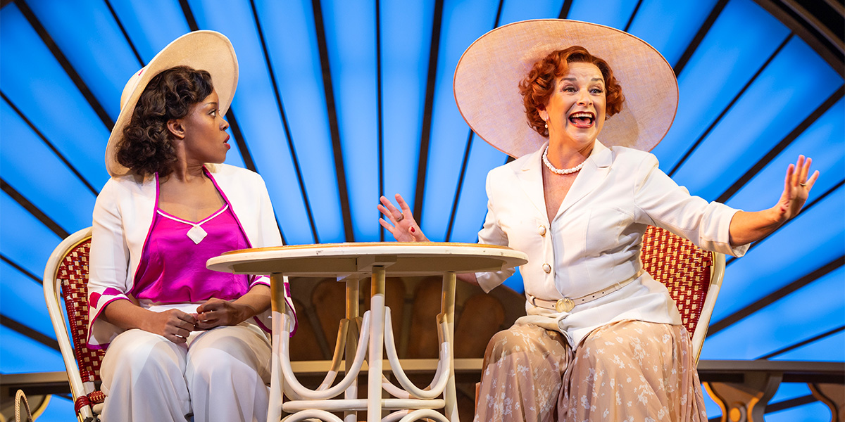 Two people sit together at a table laughing.