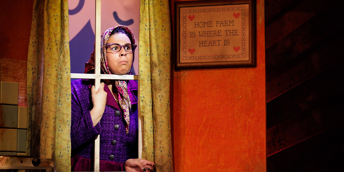 Harriett O'Grady poses confidently, wearing a vibrant costume with intricate patterns, against a neutral background.
