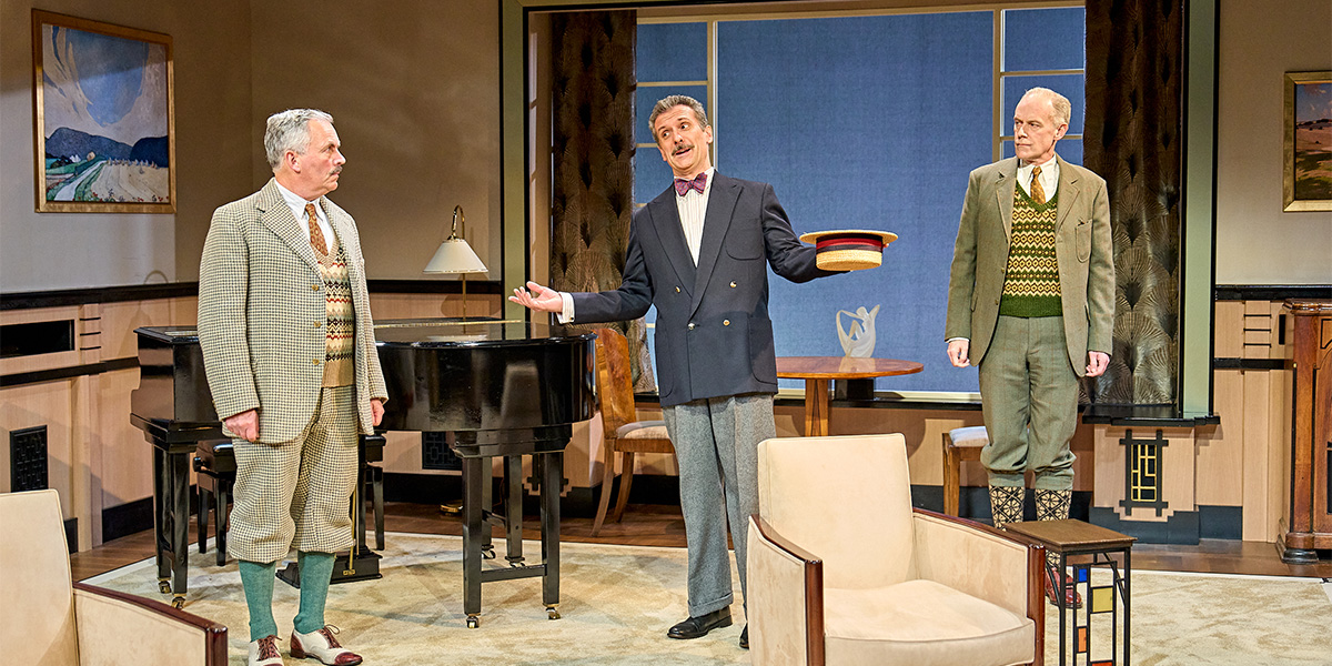 Christopher Hollis, Graham Vick, and Richard Teverson in theatrical costumes, performing on stage with dramatic lighting.