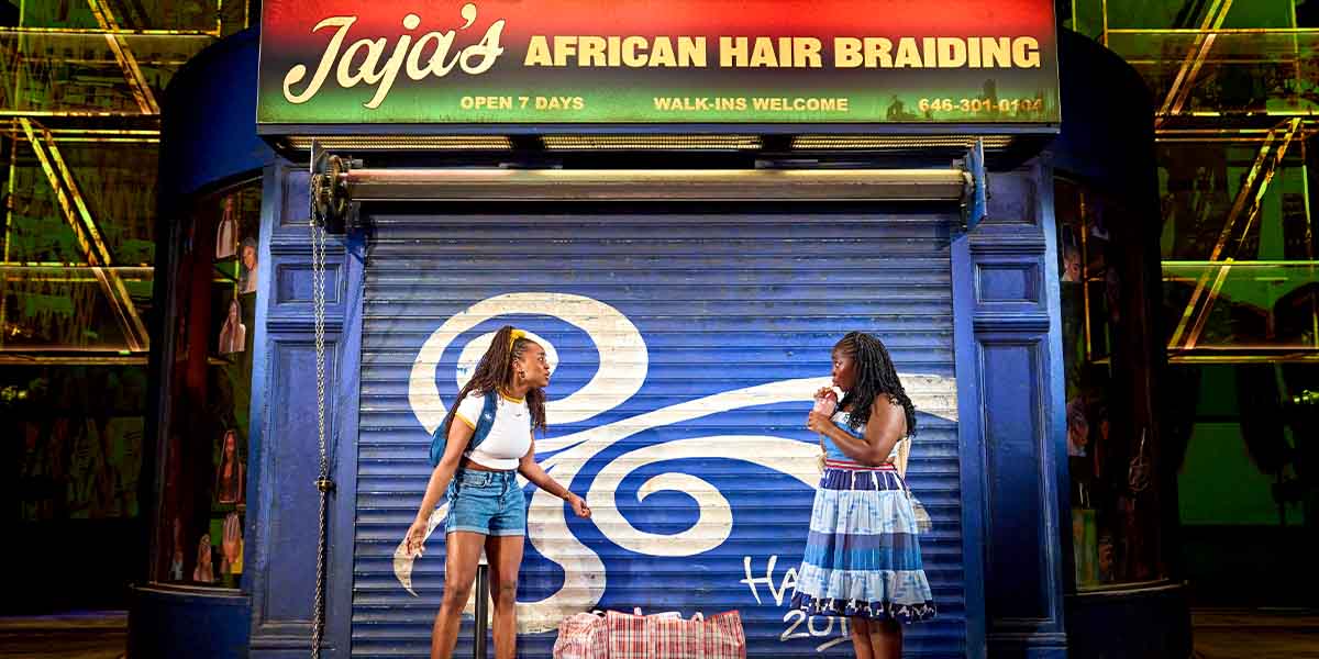 Sewa Zamba and Jadesola Odunjo pose together, showcasing intricate braided hairstyles in a bright salon setting.
