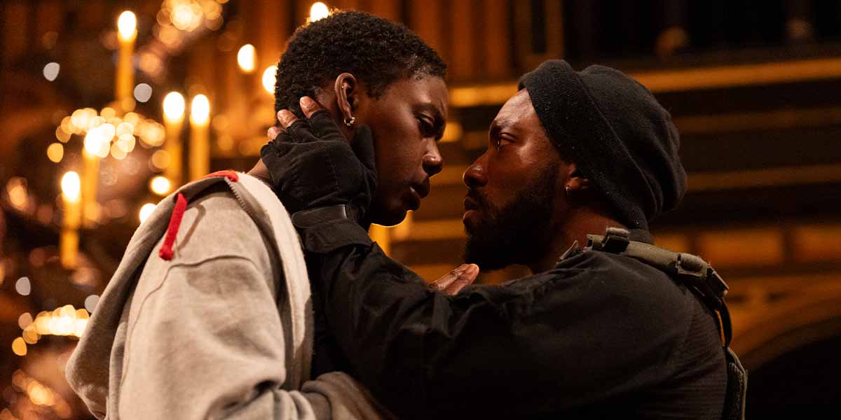 Selina Jones as Azure and Elijah Cook as Tone share an intense moment, surrounded by candlelight.