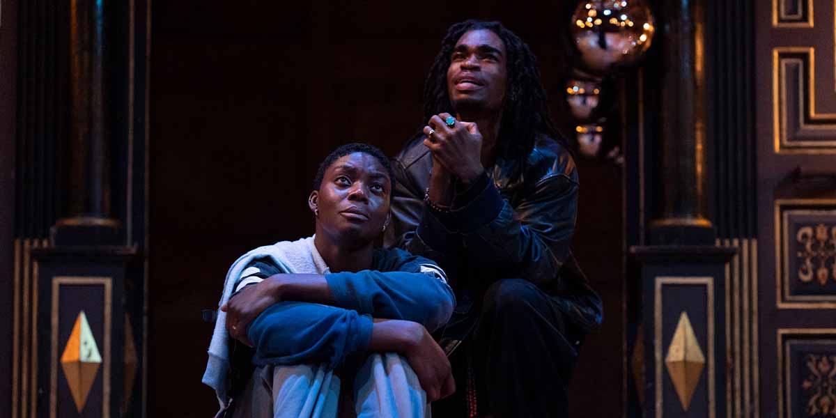 Selina Jones as Azure and Jayden Elijah as Deep, seated on stage, expressing deep emotion in dramatic lighting.