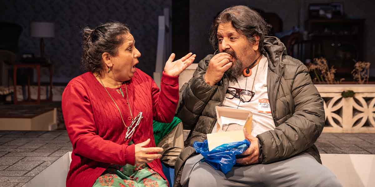 Shobu Kapoor as Hema gestures animatedly while Rehan Sheikh as Liaquat eats from a box.