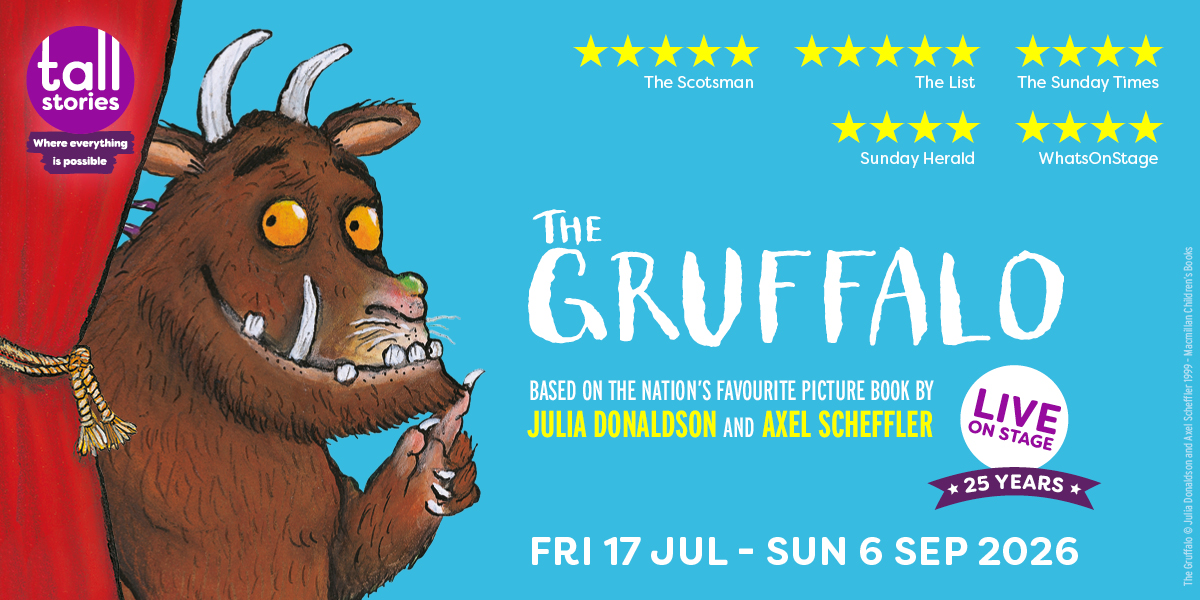 The Gruffalo character stands in a forest, surrounded by trees and foliage, with a textured brown fur coat.