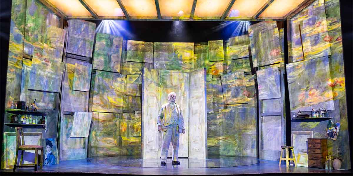 Jeff Shankley stands centre stage in a vibrant, textured set resembling Monet's artwork, illuminated by spotlights.