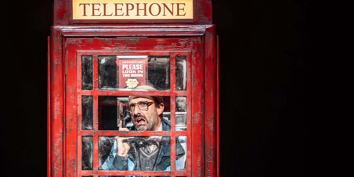 A vibrant stage scene from "Paddington The Musical," featuring actors in colourful costumes performing energetically.