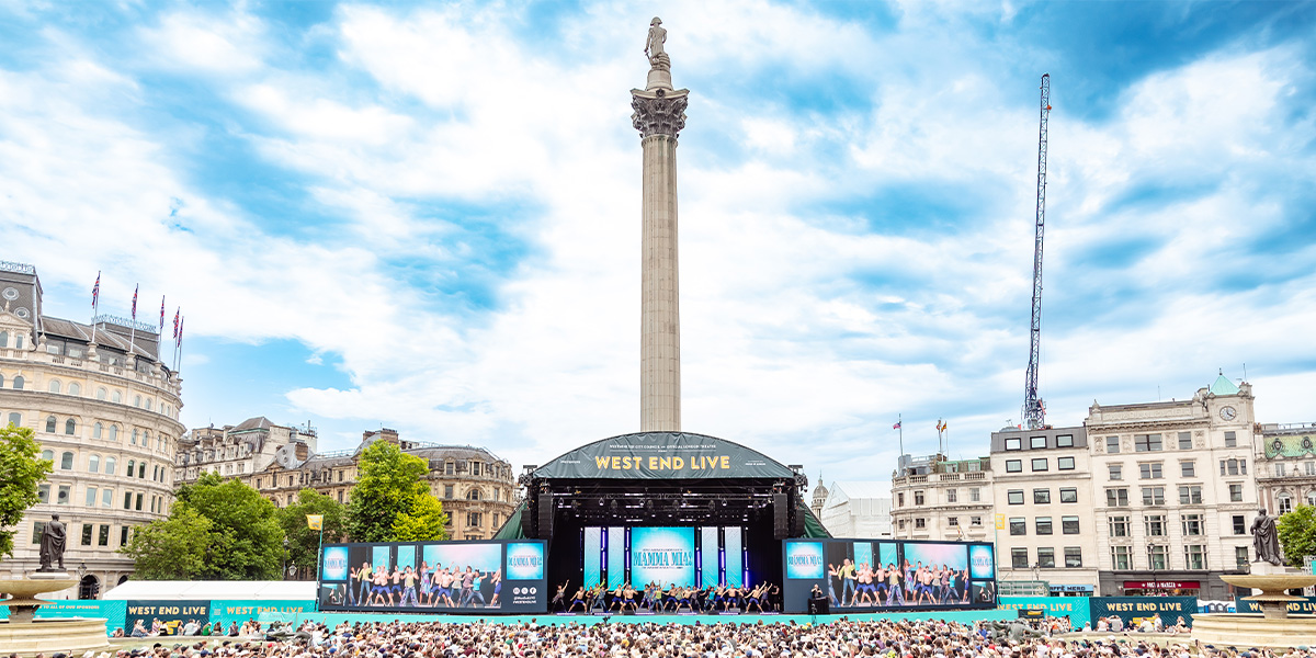 The cast of Mamma Mia! performs on stage, surrounded by a cheering crowd at West End LIVE 2025.