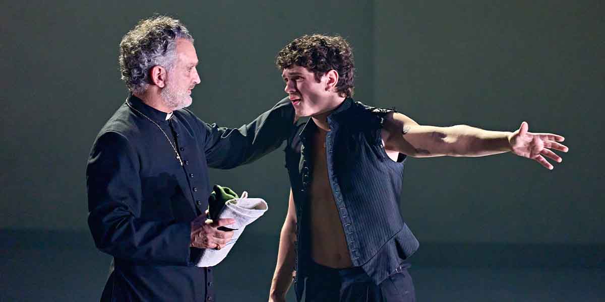 John Marquez and Noah Jupe interact on stage, with Marquez holding a cloth and Jupe gesturing.