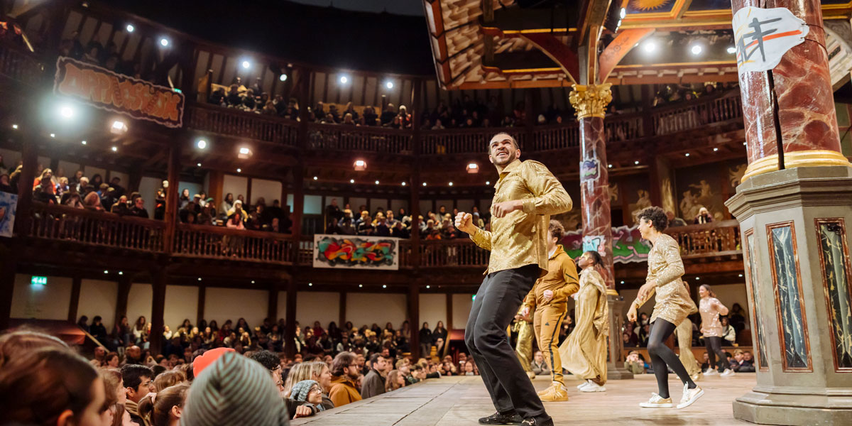 Actors performing a scene from Romeo and Juliet, dressed in period costumes, with a dramatic backdrop.