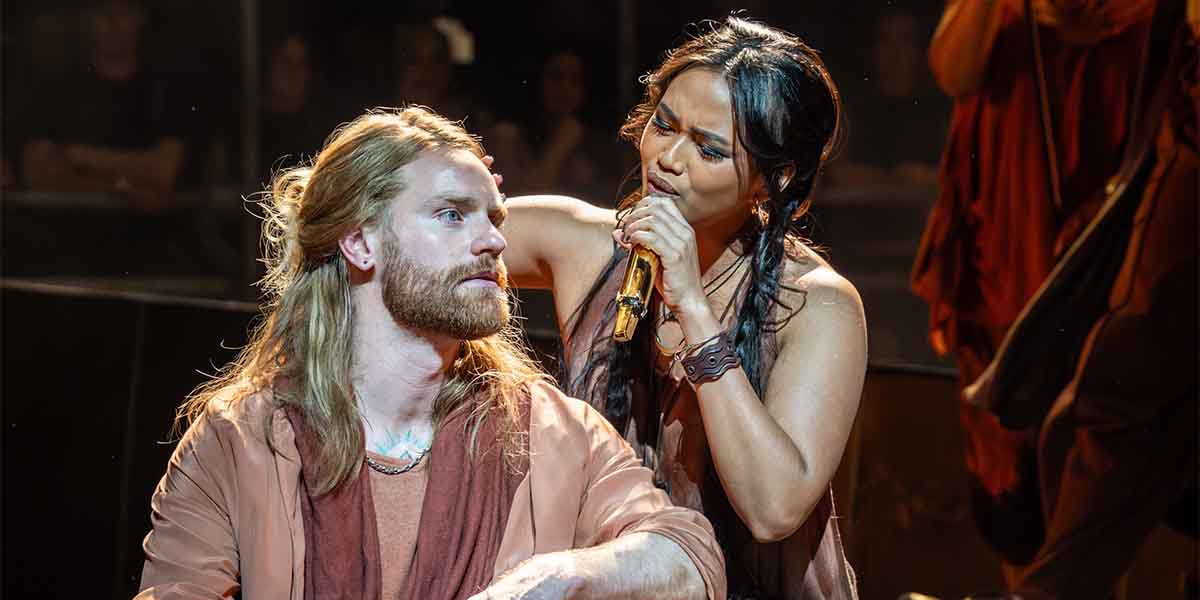 Sam Ryder and Desmonda Cathabel perform together, with Ryder seated and Cathabel singing passionately.