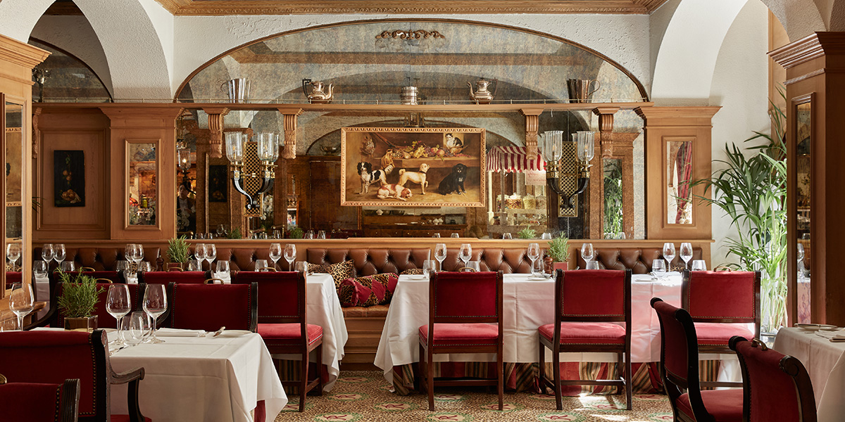 A stylish restaurant interior featuring elegant tables, dim lighting, and patrons enjoying drinks and conversation.