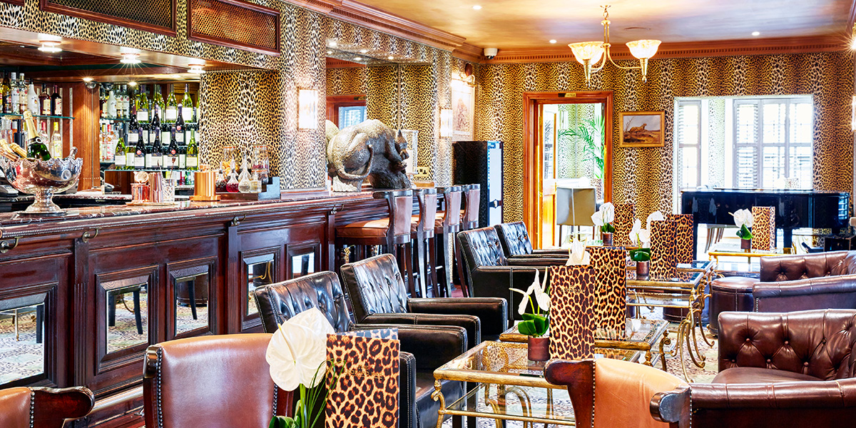 A stylish bar setting with vibrant decor, featuring patrons enjoying drinks and celebrating together.