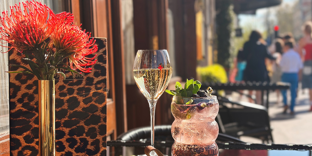 A stylish bar scene featuring a leopard print decor, with elegant seating and a polished wooden counter.