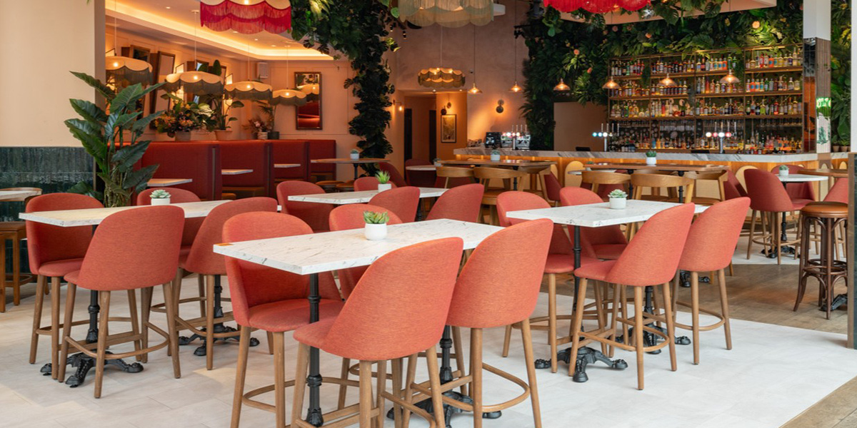 A beautifully designed glasshouse filled with lush greenery, showcasing a vibrant celebration atmosphere.
