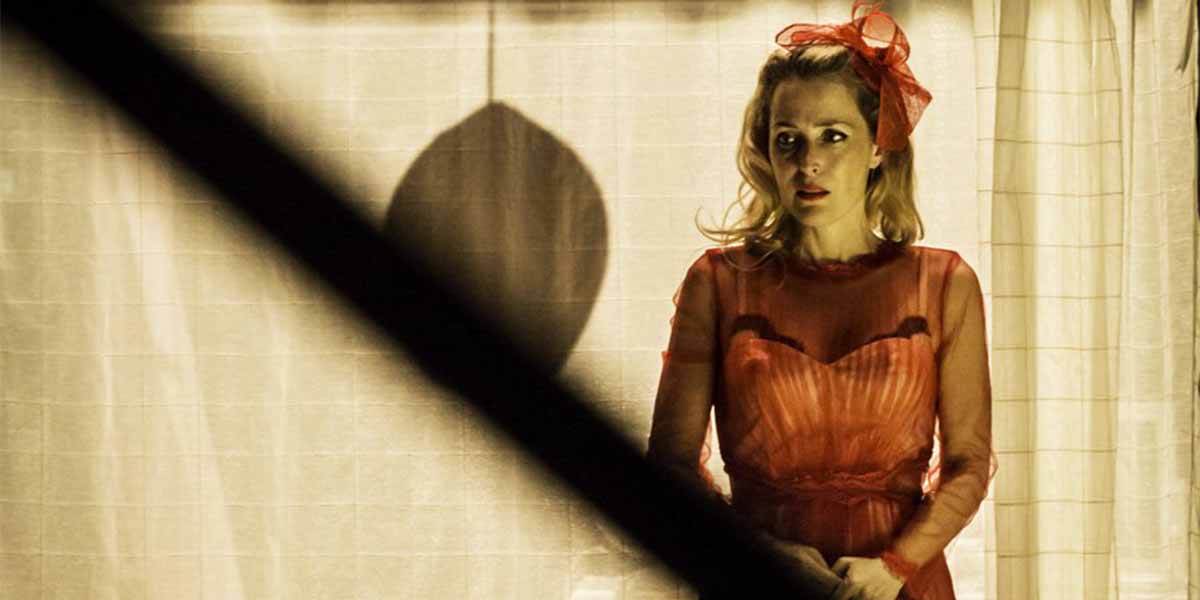 Ana Villafañe stands in a sheer red dress, looking concerned against a softly lit background.