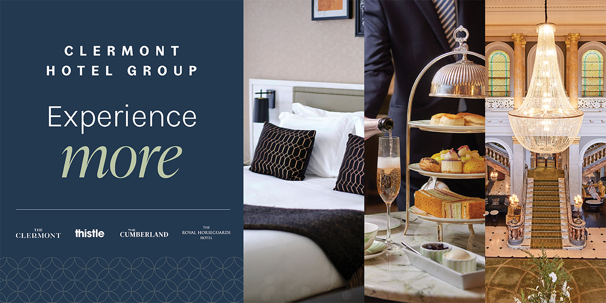 A modern hotel lobby featuring elegant furnishings, warm lighting, and a reception desk with a floral arrangement.